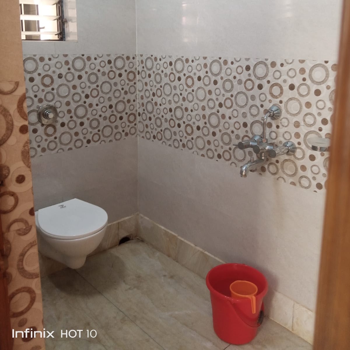 Private bathroom with patterned wall tiles and fixtures