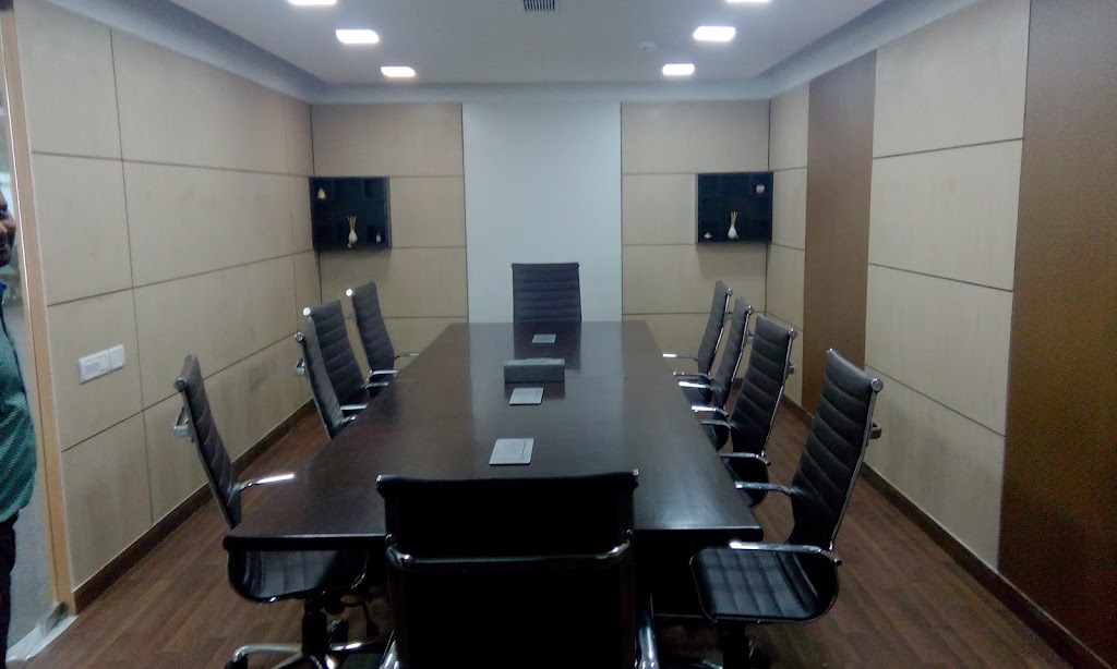 Conference room featuring a dark wood table, black leather chairs, and wood-paneled walls.