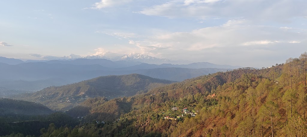 Panoramic view of snow-capped Himalayan peaks and sunlit valley