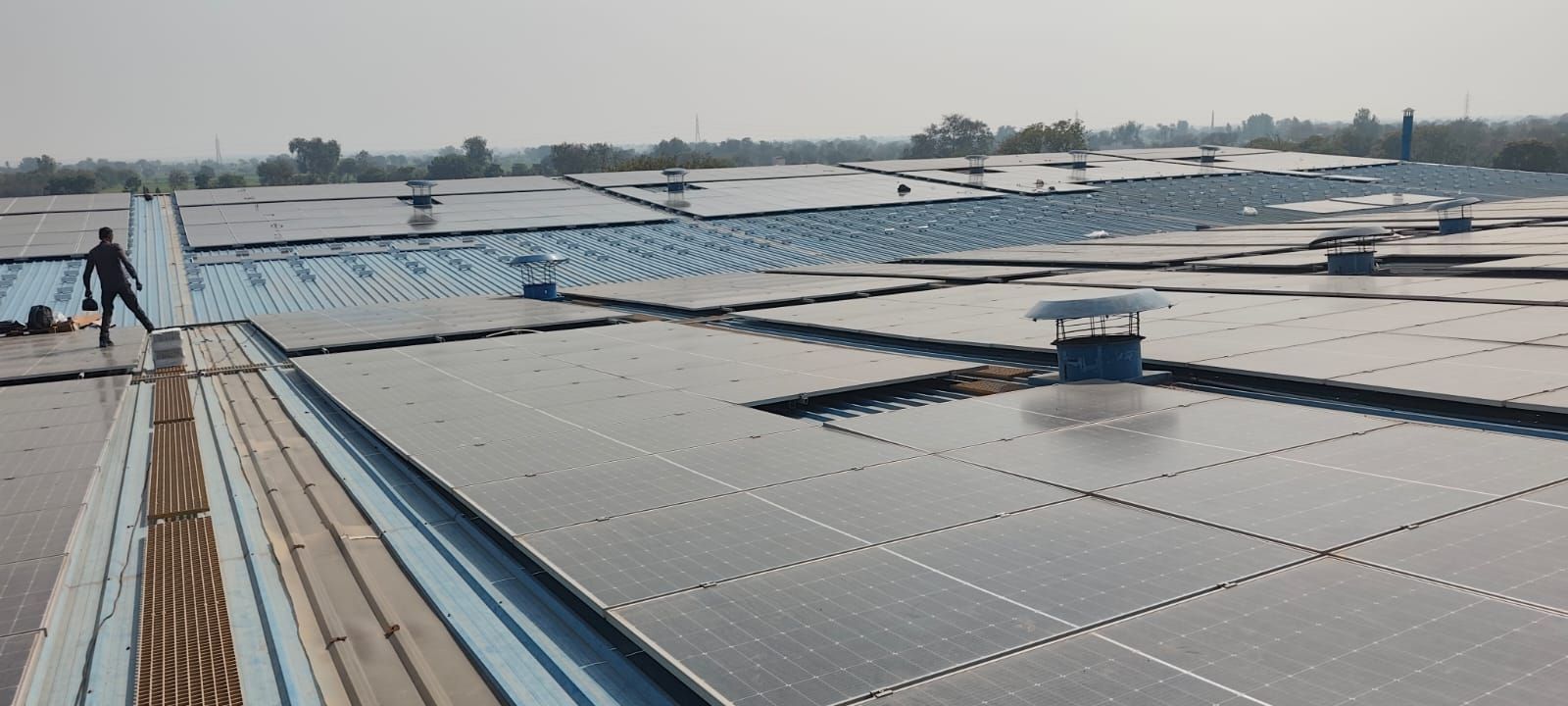 Expansive commercial rooftop solar panel installation spanning industrial corrugated roofs