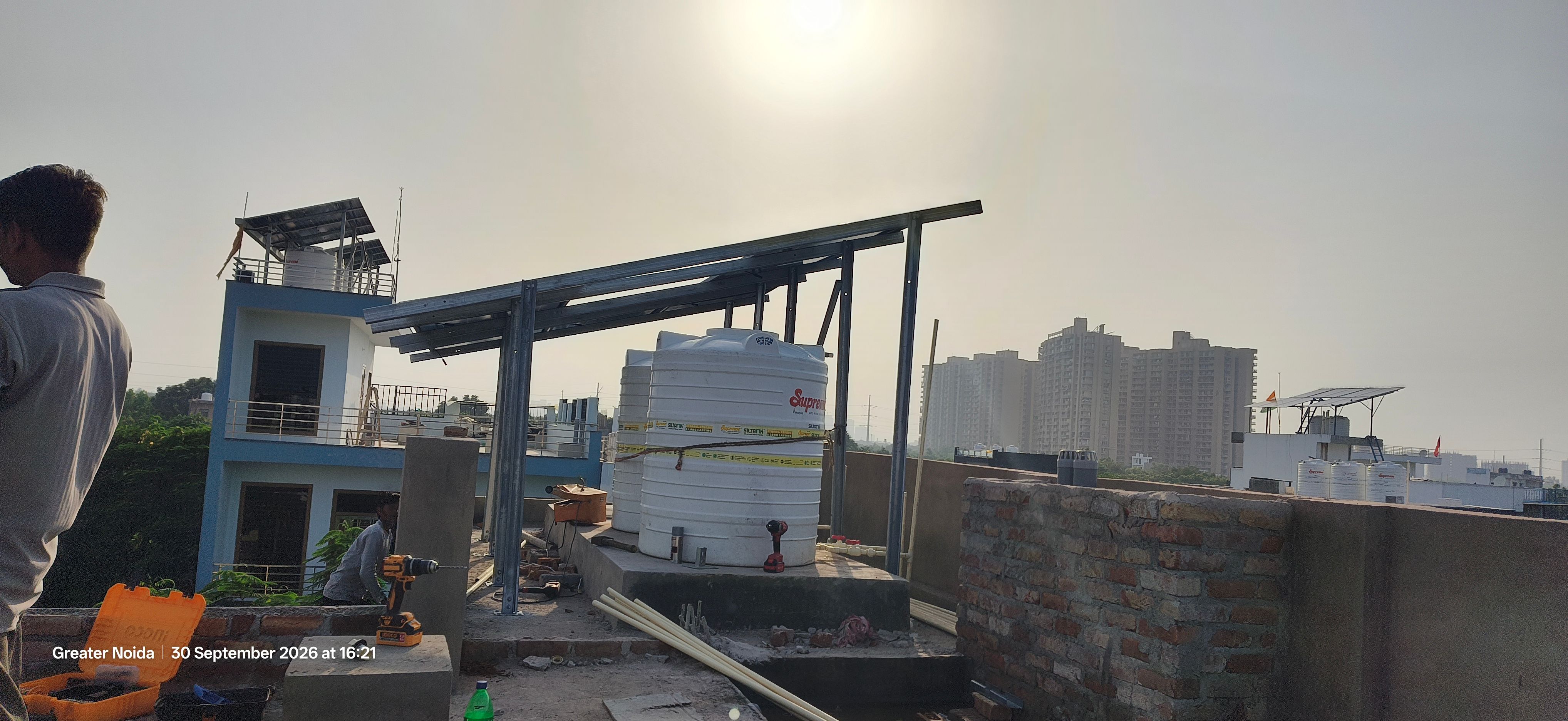 Rooftop solar mounting frame erected above overhead water storage tanks